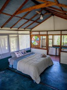 a bedroom with a large bed in a room with windows at Vila Cosmica in Lagoinha