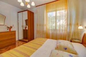 a bedroom with a bed and a window and a dresser at Apartman Mirjana 1 in Mali Lošinj