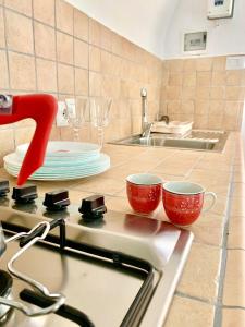 eine Küche mit zwei roten Tassen auf einem Herd in der Unterkunft Bed & Breakfast Acquamarina in Castro di Lecce