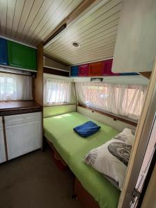 a small room with a green bed in a trailer at karavana.ta in Chernomorets