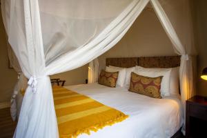 a bedroom with a white bed with a canopy at Moya Safari Lodge & Villa in Hoedspruit