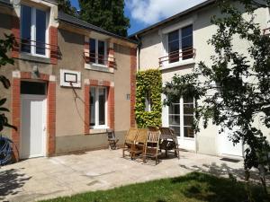 a patio in front of a house with two chairs at Les jardins de Beauverger in Le Mans