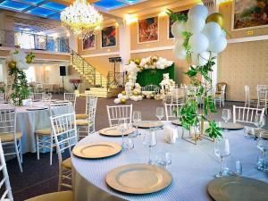 um salão de banquetes com mesas e cadeiras e um palco em Hotel Rais em Târgu Jiu