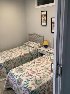 Un dormitorio con dos camas y una mesa con lámpara. en Apartamentos Costamar, en Arona 7 fotos más