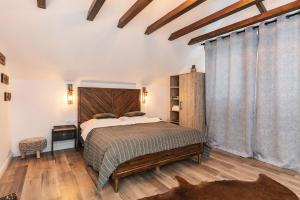 a bedroom with a large bed with a wooden headboard at Natura Magura in Buzău