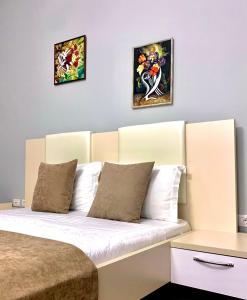 a bedroom with a bed with two pictures on the wall at Diamond Beach Residence Hotel in Durrës