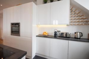 une cuisine avec des placards blancs et un comptoir dans l'établissement Appartement 4 chambres vue mer Intra-Muros, parking inclus, à Saint-Malo
