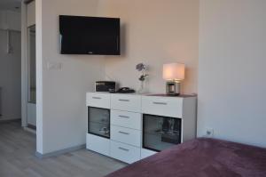a white dresser with a television on a wall at Bellevue Apartment in Zagreb