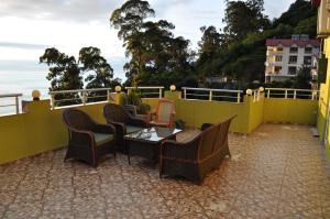 Un patio con sillas y una mesa en el balcón. en Akhmed Guest House, en Kvariati