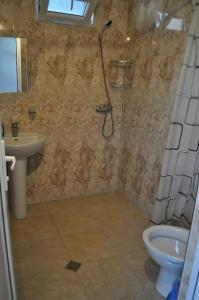 a bathroom with a shower and a sink and a toilet at Akhmed Guest House in Kvariati