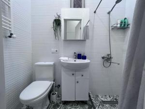 Un baño blanco con inodoro y lavabo. en STUDIO near the Round garden, en Tiflis 16 fotos más