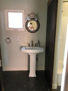 a bathroom with a white sink and a mirror at 1/F 2 bed rooms in Pittsburgh