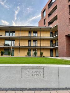 una señal de la puerta del campus delante de un edificio en CAMPUS CARRÉE - Modernes und zentrales Apartment in Kassel en Kassel