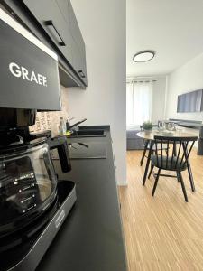 a kitchen with a stove and a table in a room at CAMPUS CARRÉE - Modernes und zentrales Apartment in Kassel in Kassel