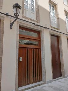 a building with a wooden door and a street light at Apartamentos Tras dos Fornos in Chantada