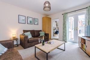 un soggiorno con divano e tavolo di Modern apartment in Crewe by 53 Degrees Property, ideal for long-term Business & Contractors - Sleeps 4 a Crewe