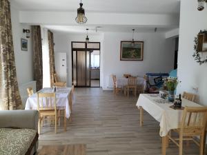 a dining room with tables and chairs and a living room at Conacul Doamnei Nucșoara in Nucşoara
