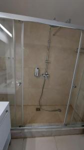 y baño con ducha y puerta de cristal. en Camera de închiriat Blaxy Premium Resort, en Olimp