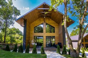 a modern house with a wooden roof at Cervus Magura in Măgura