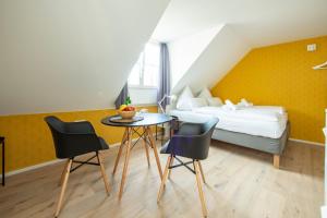 um quarto com uma cama, uma mesa e cadeiras em Gästehaus am Schlossplatz Z. 3 em Meersburg