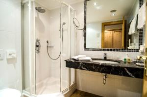 a bathroom with a shower and a sink and a toilet at Sporthotel Almhof in Ischgl