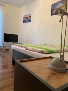 um quarto com uma cama e uma secretária com um candeeiro em Pension32 em Burg bei Magdeburg