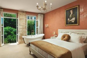 a bedroom with a bed and a bath tub and a sink at Nobili Boutique Hotel in Chania Town