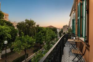 a balcony with a table and chairs and trees at Nobili Boutique Hotel in Chania Town