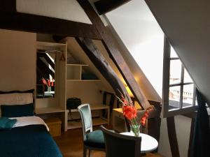 a room with a bed and a table with chairs at Au coin romantique Vernon Giverny in Vernon