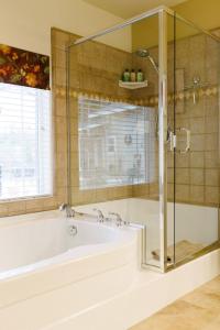 een badkamer met een bad en een glazen douche bij Red Tail Ranch in Groveland
