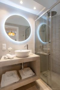 ein Bad mit einem Waschbecken und einer Dusche mit einem Spiegel in der Unterkunft Nerites residence in Apollonia Sifnos in Apollonia