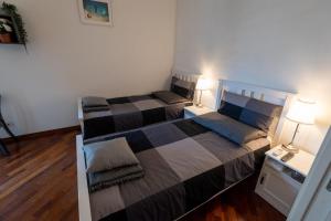 two beds in a small room with two lamps at SUITE184 in Bari