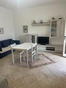 un soggiorno con tavolo bianco e divano di Appartamento La Guglia a Cala Gonone