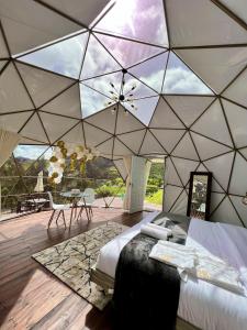 a bedroom with a large tent with a ceiling at Golden Glamping in Guatavita