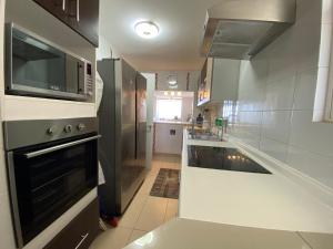 a kitchen with a stove and a microwave at Dpto 1er nivel en La Serena in Coquimbo +29 photos