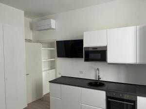 une cuisine blanche avec un évier et un micro-ondes dans l'établissement PRESTIGE BOUTIQUE HOMES - Arco della Pace 2, à Milan