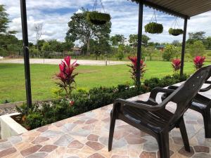 Dos sillas negras sentadas en un patio con un parque en Cabañas Campestres en Villavicencio en Villavicencio