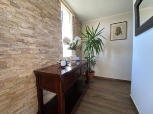 a room with a wooden table and a brick wall at Dpto 1er nivel en La Serena in Coquimbo