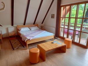a bedroom with a bed and a table and windows at Prenoćište/Restoran Lovac in Bihać