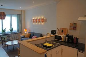 eine Küche mit einer Mikrowelle und ein Wohnzimmer in der Unterkunft Apt in center of Ostende 20min from Bruges in Ostende