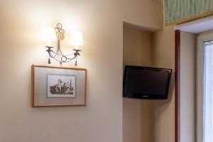 a room with a tv and a picture on the wall at Hotel Suite Ares in Naples