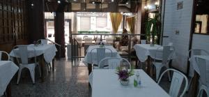 ein Restaurant mit weißen Tischen und weißen Stühlen in der Unterkunft Hotel Continental in Montevideo