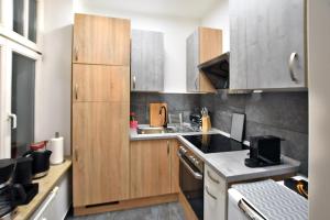 a kitchen with wooden cabinets and a stove top oven at Stylisches City Appartment in Chemnitz bester Lage! in Chemnitz