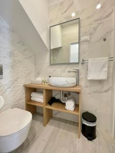 uma casa de banho com um lavatório, um WC e um espelho. em Ida Old Town Rooms em Dubrovnik