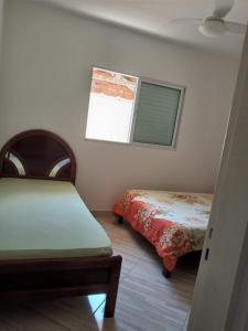 1 dormitorio con 2 camas y ventana en chalés Isabela, en Ubatuba