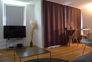ein Wohnzimmer mit einem TV und einem Tisch in der Unterkunft Ferienhäuschen Möwenschiss, 500m zum Strand in Graal-Müritz