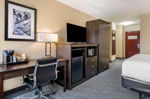 a hotel room with a bed and a desk with a computer at Best Western Charleston in Charleston