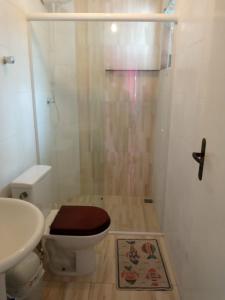 y baño con ducha, aseo y lavamanos. en chalés Isabela, en Ubatuba