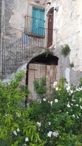 a building with a door and a balcony and flowers at Casa Fonte Vallone in Pacentro