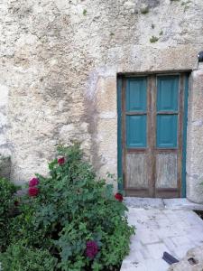 a building with a window and a bush with flowers at Casa Fonte Vallone in Pacentro